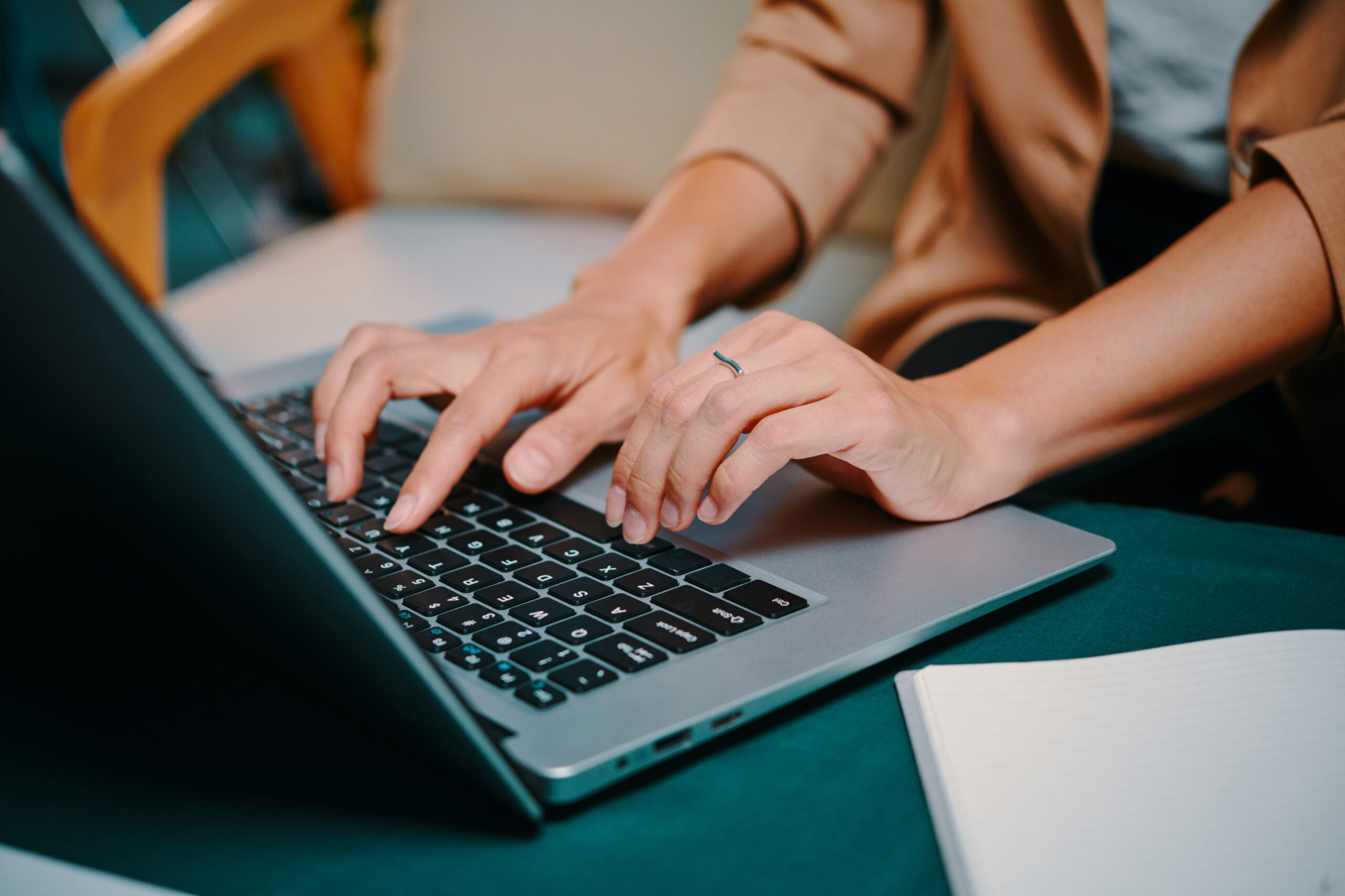 Dameshanden die op een laptop aan het typen zijn